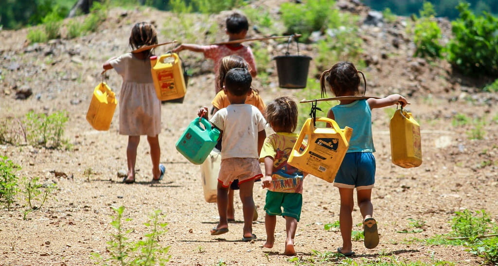 niños recogiendo agua