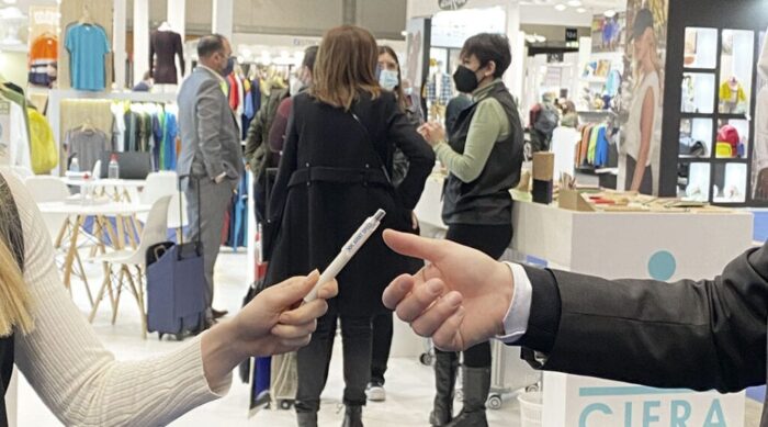 Entrega de un bolígrafo en una feria comercial