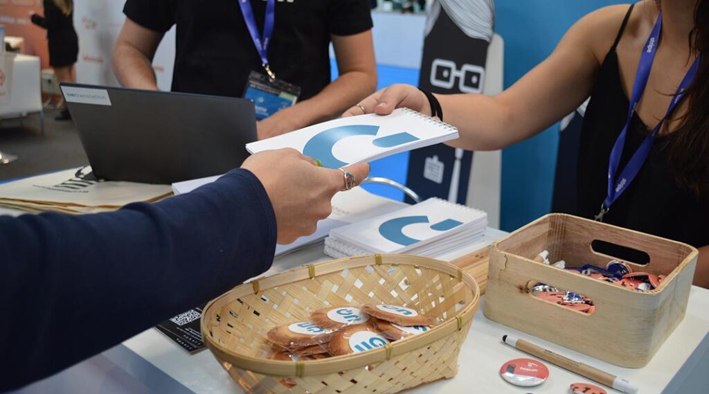 Entrega de regalos promocionales a clientes en una feria