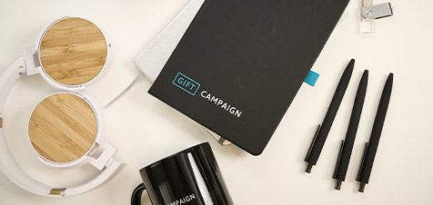 Libreta, auriculares, taza y bolígrafos publicitarios