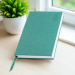 Agenda diaria en español y portugués con cubierta de papel artesanal A5 color verde suave vista de ambiente