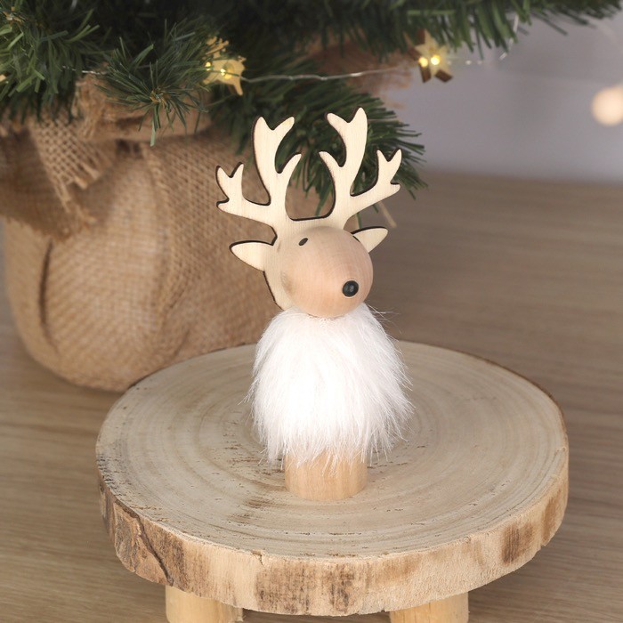 Adorno navideño de madera en forma de reno con pelaje blanco vista de ambiente