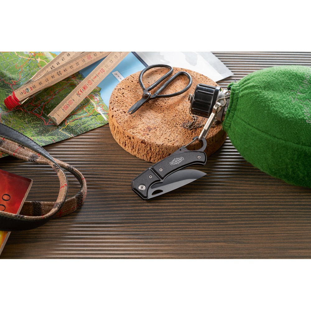 Navaja de bolsillo de acero y metal con cierre y mosquetón vista bodegón