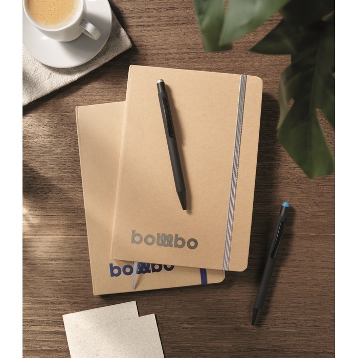 Libreta de cartón con banda y marca páginas a color hojas a rayas A5 color plateado vista bodegón Libreta de cartón con banda y marca páginas a color hojas a rayas A5 color plateado vista bodegón