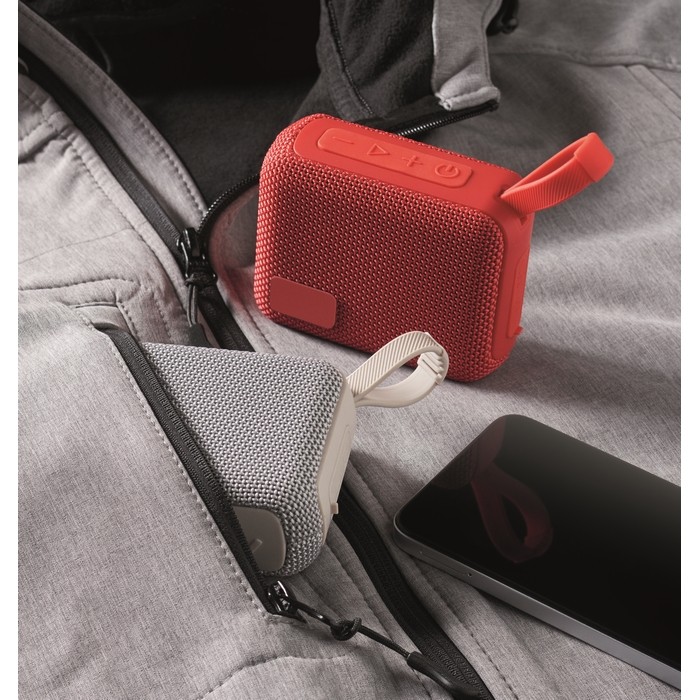 Pequeño altavoz inalámbrico con asa a juego para transporte color rojo vista bodegón Pequeño altavoz inalámbrico con asa a juego para transporte color rojo vista bodegón