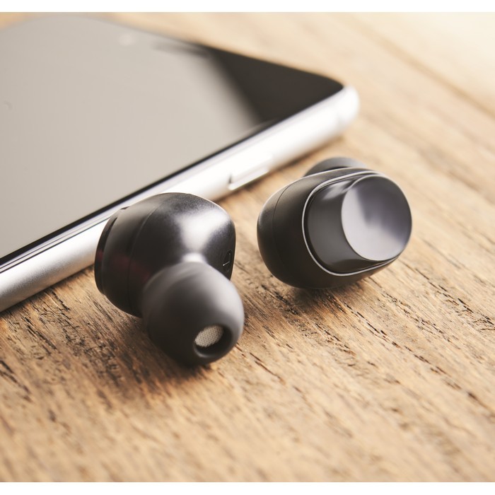 Auriculares inalámbricos con estuche color negro vista bodegón Auriculares inalámbricos con estuche color negro vista bodegón