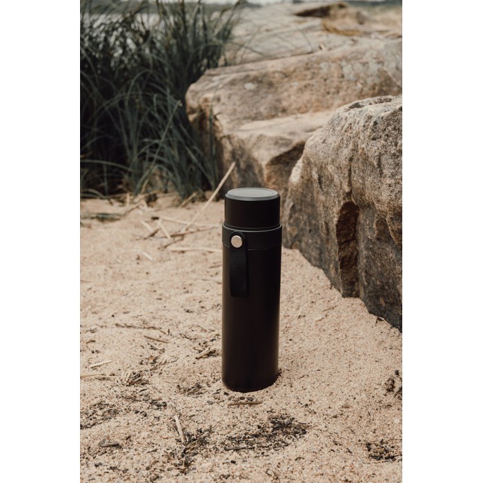 Termo en acero inoxidable reciclado con asa de transporte 750ml color negro vista de ambiente Termo en acero inoxidable reciclado con asa de transporte 750ml color negro vista de ambiente