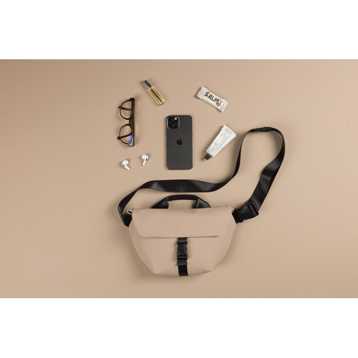 Bandolera urbana en material reciclado con correa ajustable color marfil vista de ambiente