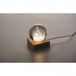 Bola de cristal edición navideña con luz LED sobre base de madera color madera vista fotografía tercera vista