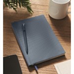 Libreta de tapa rígida  con bolígrafo en el interior A5 hojas a rayas color azul marino vista bodegón