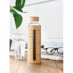 Botella de vidrio con medidor color madera vista bodegón